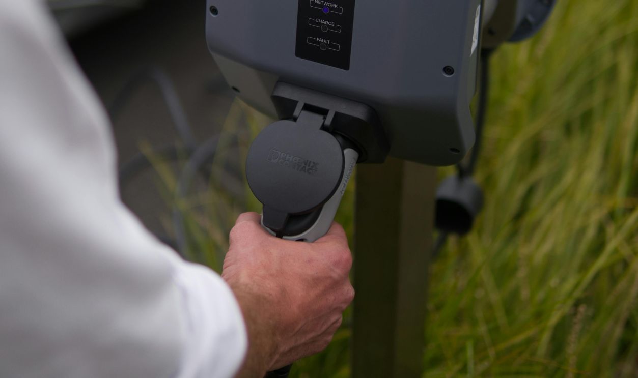 Close-Up View of a Person Holding the EV Charger