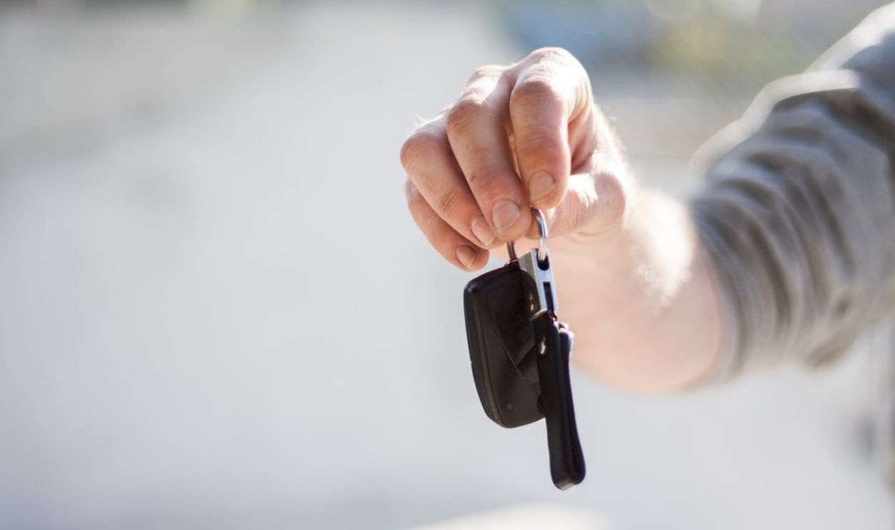 Person in Grey Shirt Handing Keys