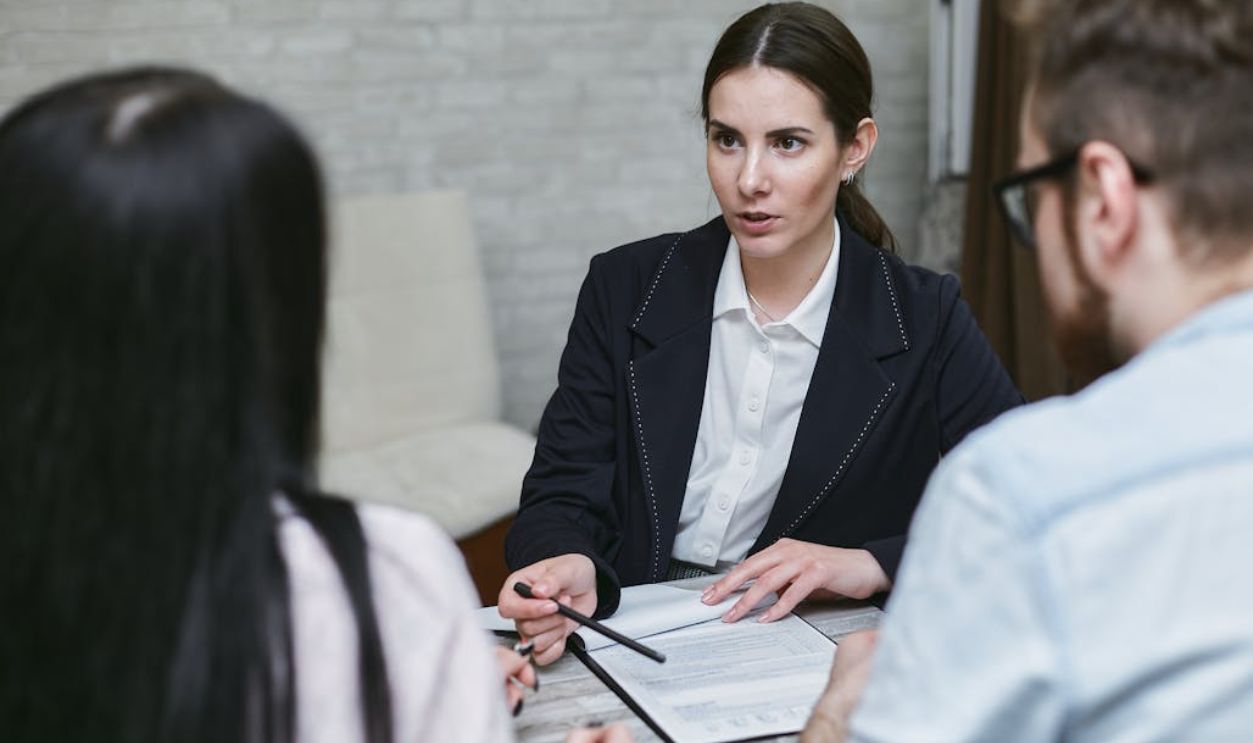 Woman in Black Blazer Talking to Her Co-workers