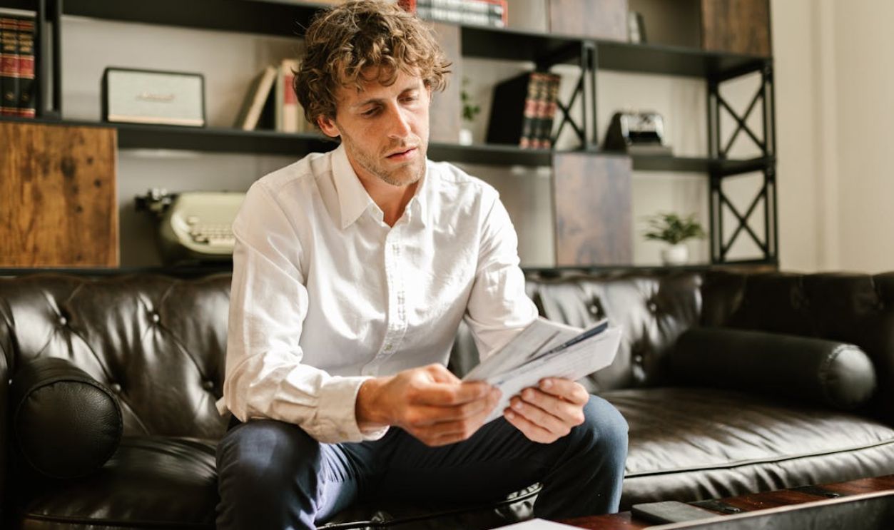 Man in White Long Sleeve Shirt Sitting on Sofa