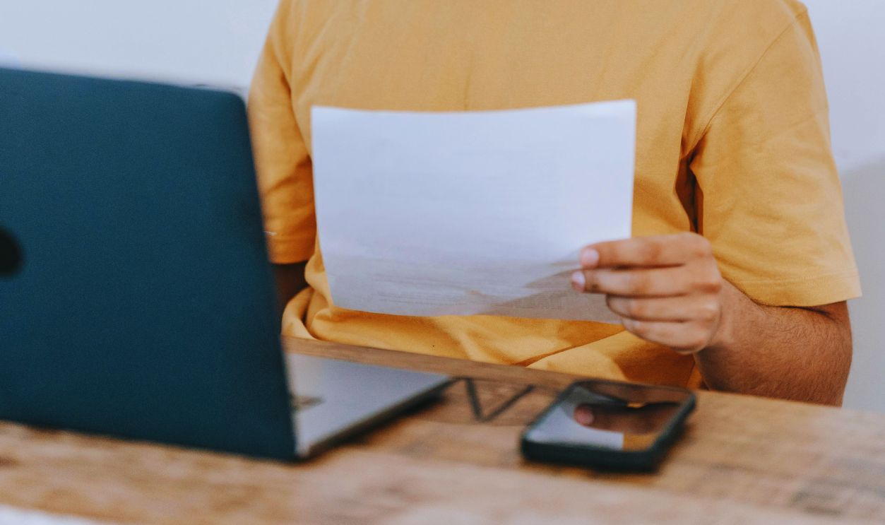 Ethnic man reading documents at workplace