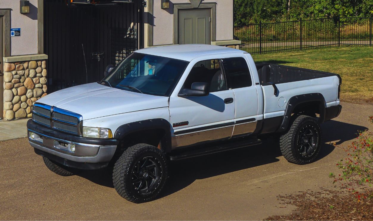 White Pickup Truck Near a Garage with Roof Tiles
