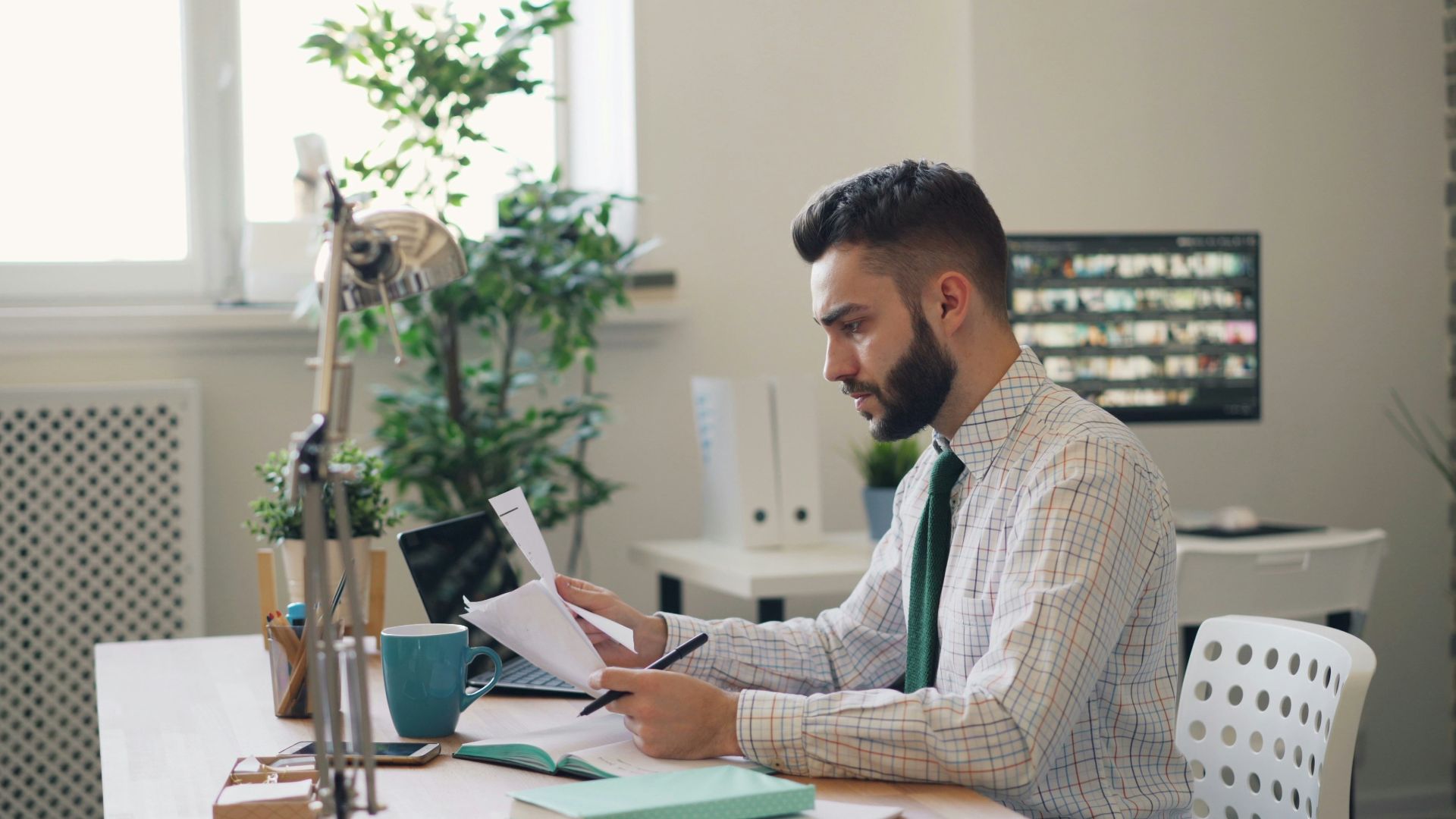 a man sitting at a desk with a laptop and papers