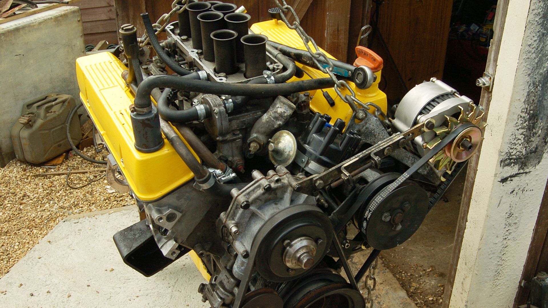 A 3.5-litre Rover V8 engine from a 1986 Range Rover under restoration, with non-standard yellow-painted sump and rocker covers.