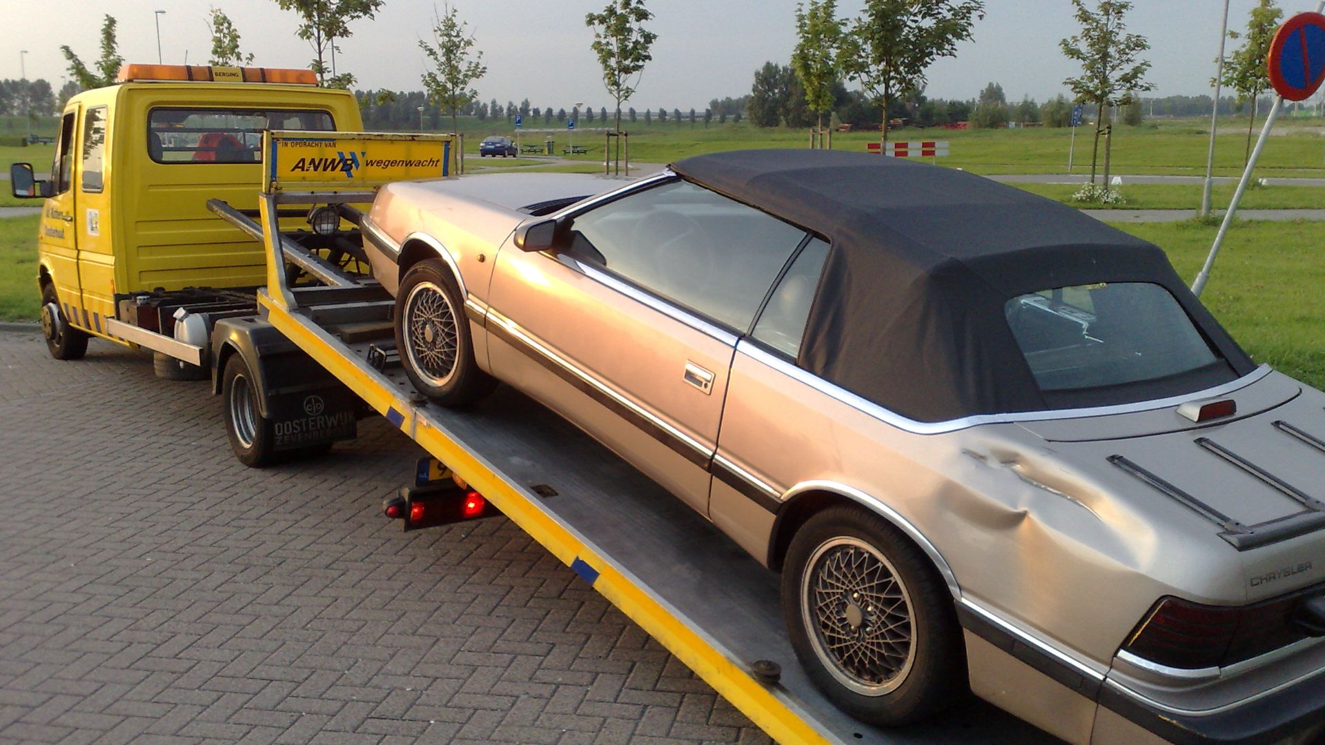 Tow truck tows a car after a collision with a truck.
