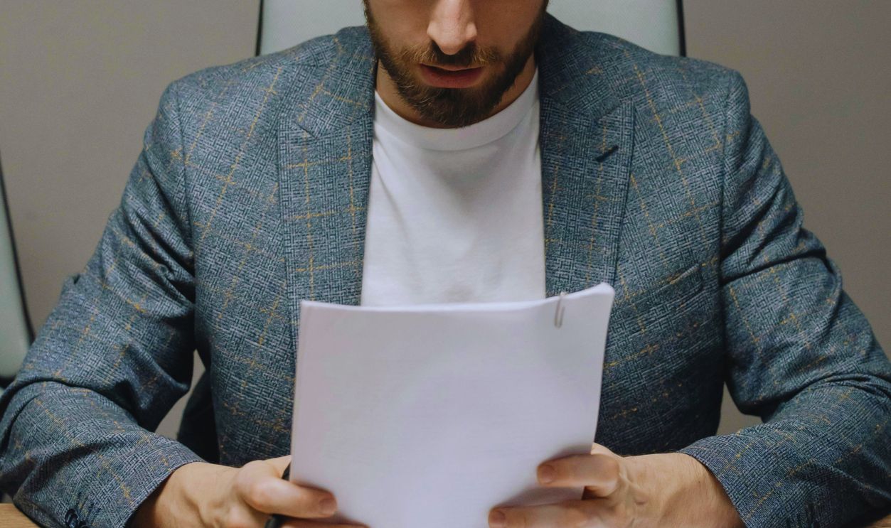Man in Gray Suit Jacket Holding Papers