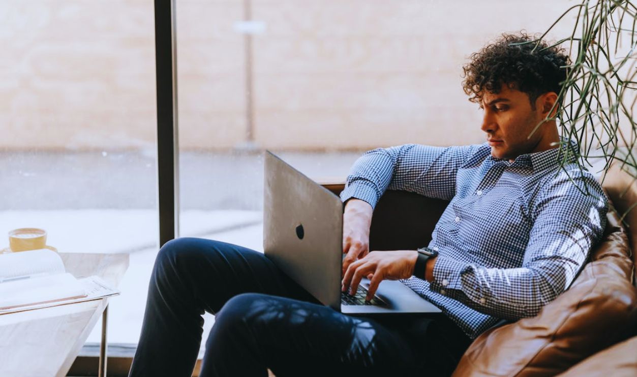 A Man Using a Laptop while Sitting on a Couch