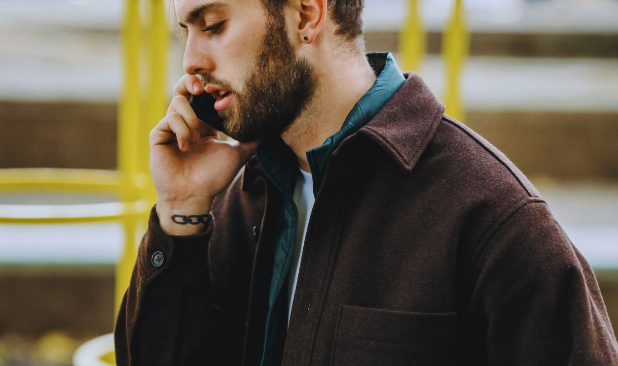 Pensive man talking on smartphone on street