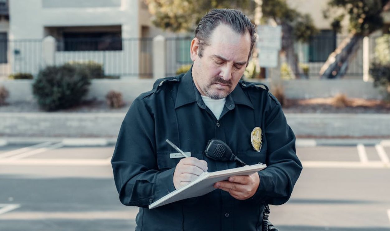 A Bearded Police Man Writing on Paper