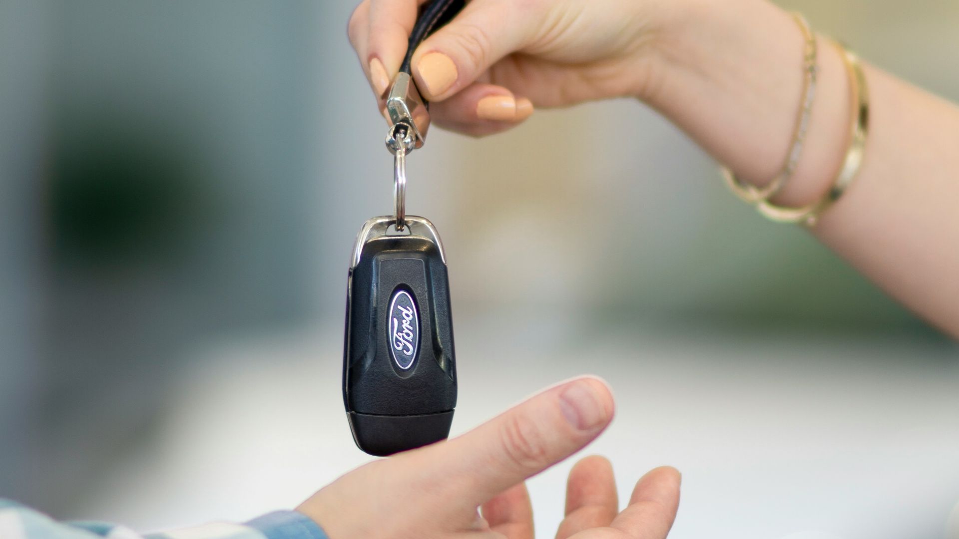 A person handing a car key to another person