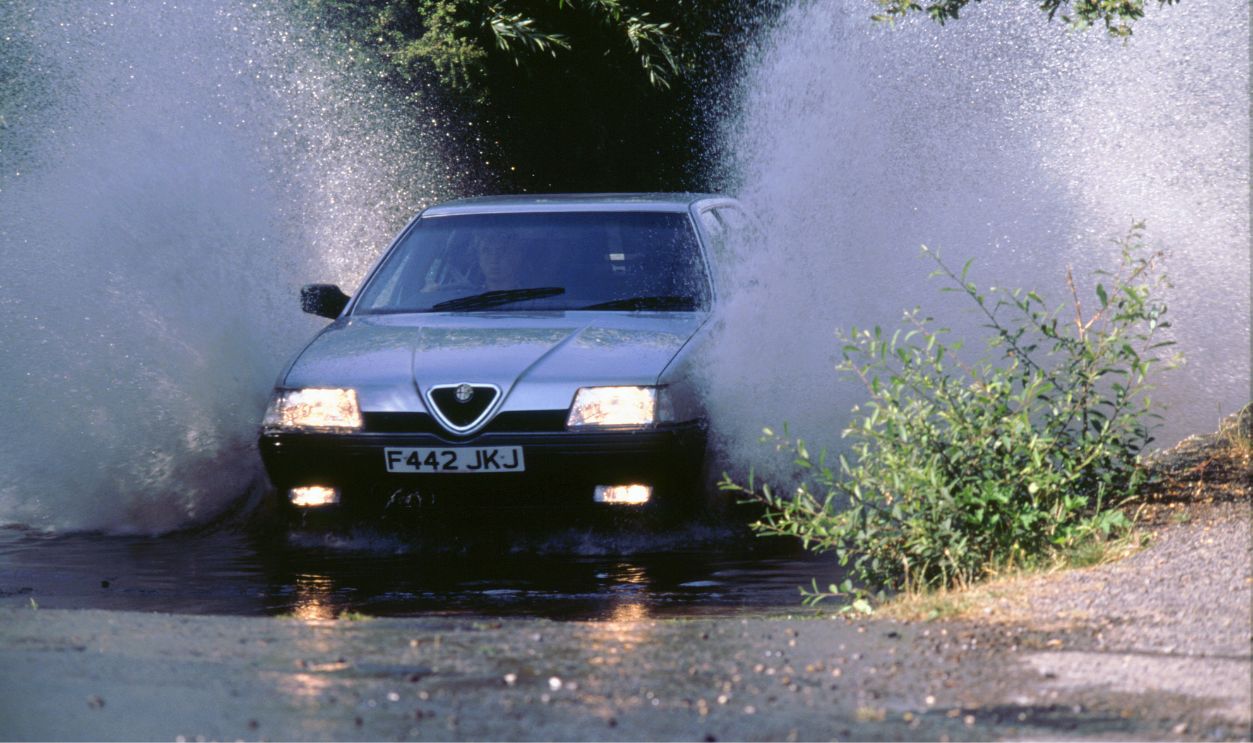 Gettyimages - 534270490, 1989 Alfa Romeo 164 driving through a ford 1989 Alfa Romeo 164 driving through deep ford, 2000.