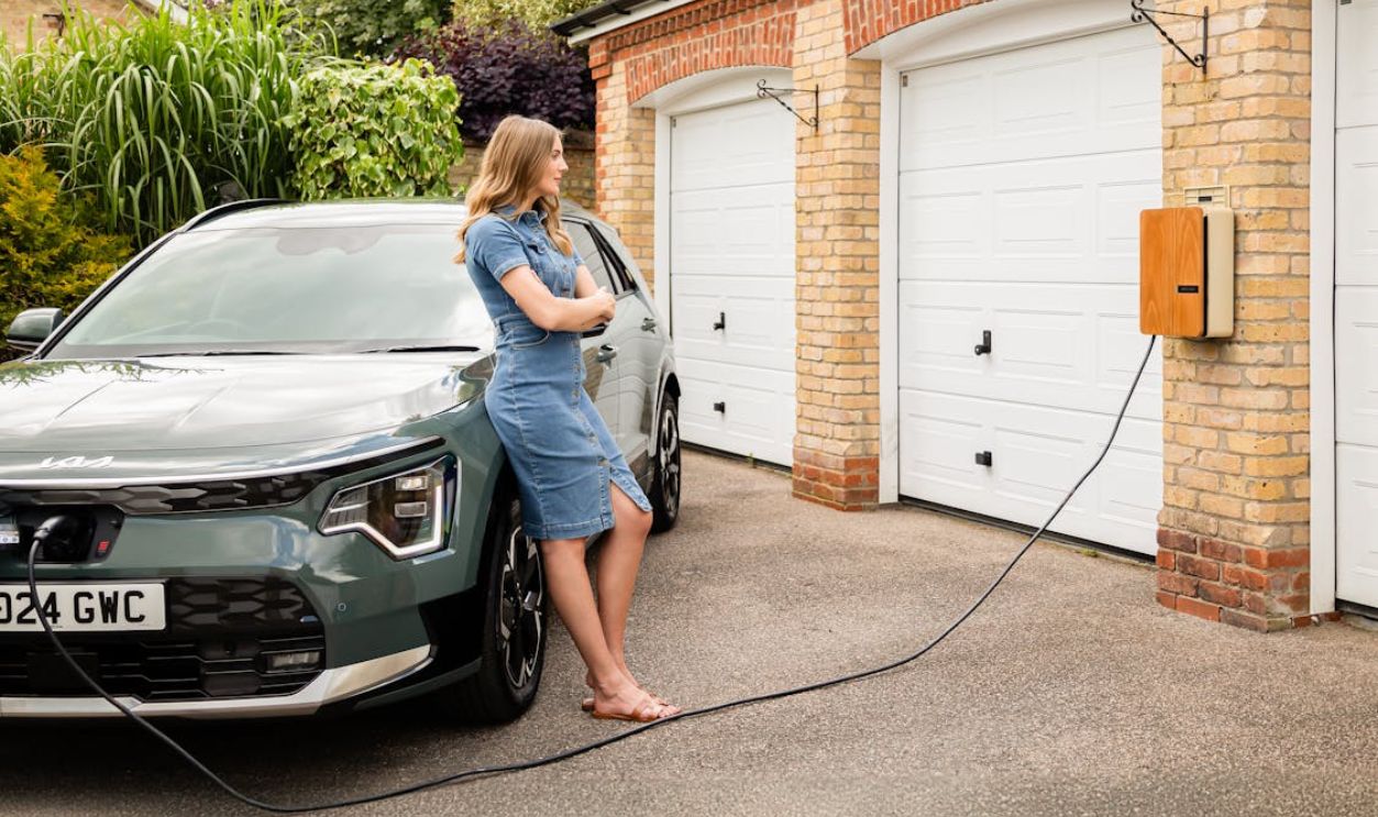 Young lady with an Andersen home electric vehicle charge point and all-electric Kia Niro