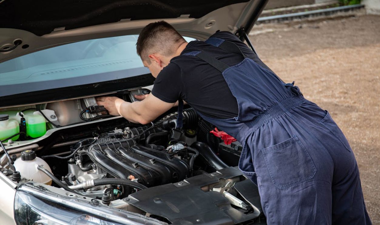 Man in Black Crew Neck T Shirt Fixing a Car