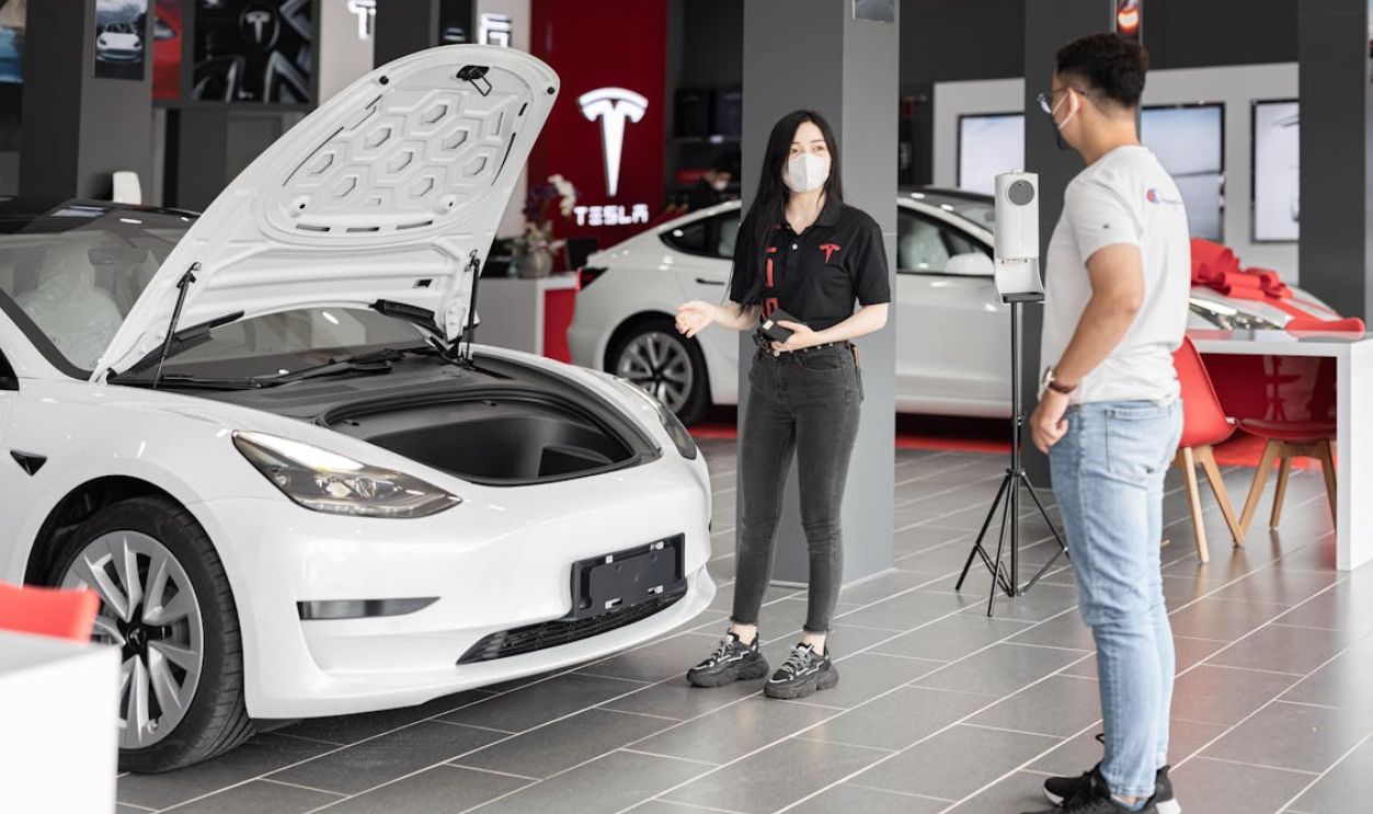 A Person Looking at a Tesla Model 3 at a Car Dealership