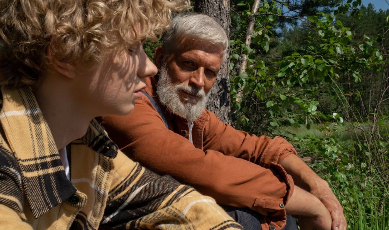 Grandfather and Grandson Sitting in a Forest