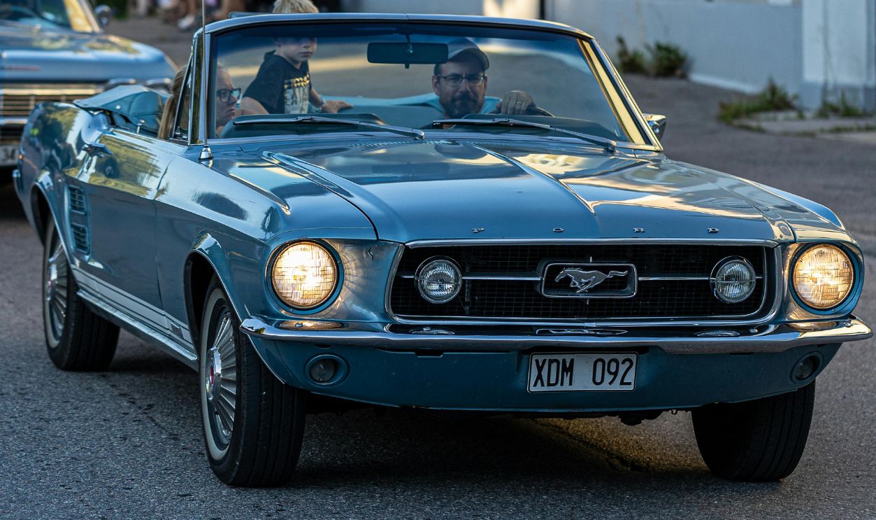 Man Driving a Blue Vintage Top Down Car