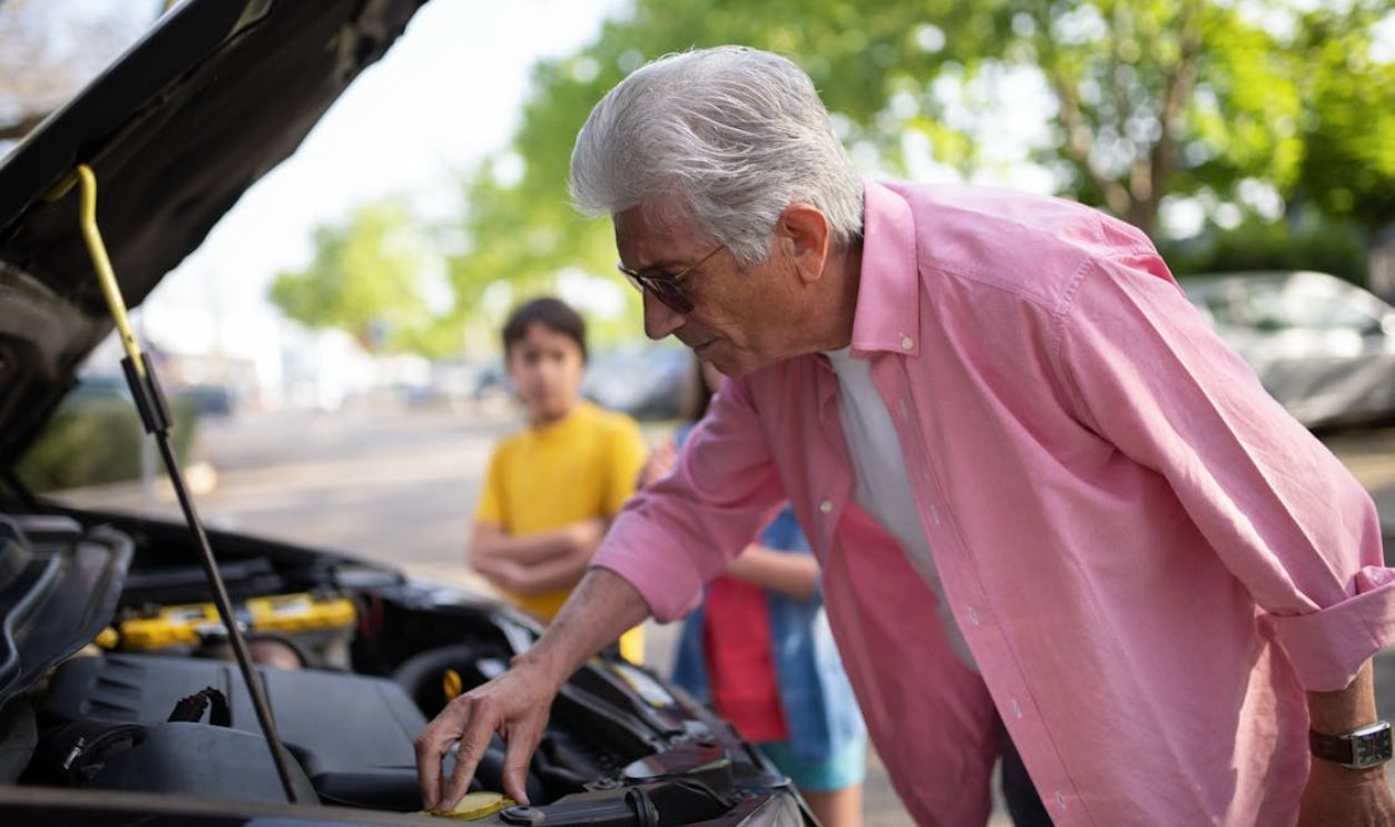 Elderly Man Repairing a Car