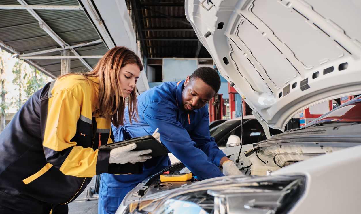EV car check, mechanic workers coworker inspects and maintains service of electric engine and battery in fixed automobile garage station, professional technology transportation industry business.