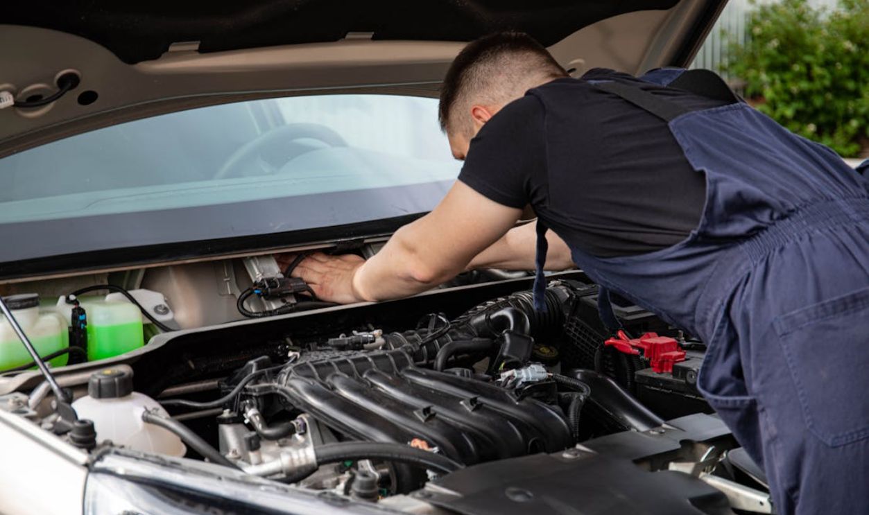 Man in Black Crew Neck T Shirt Fixing a Car
