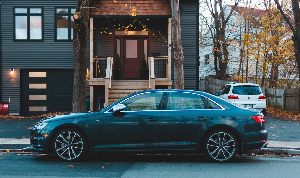 Black Sedan Parked Beside Brown Wooden House