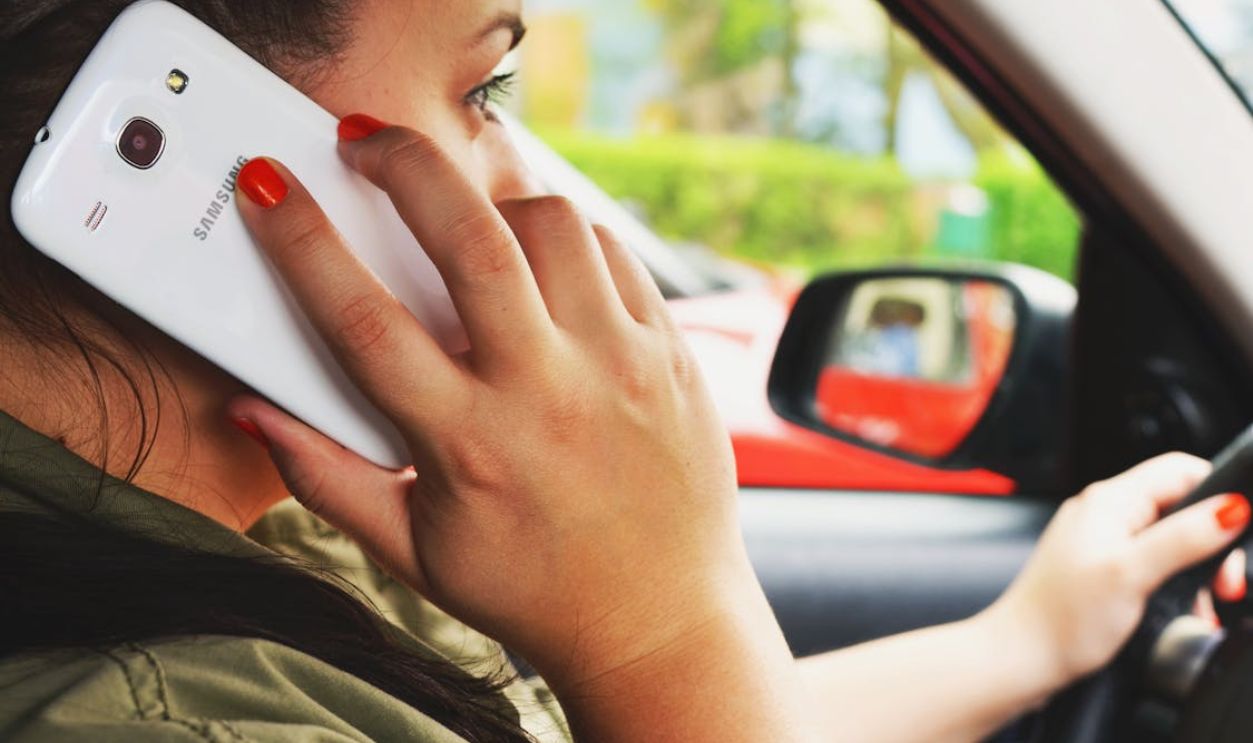Woman Driving Car While Calling on Smartphone