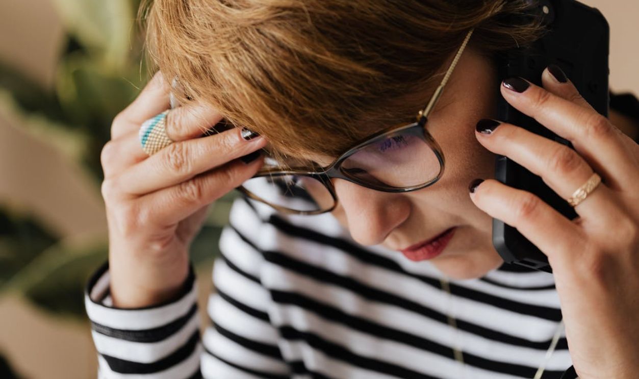 Anxious woman having phone conversation in office