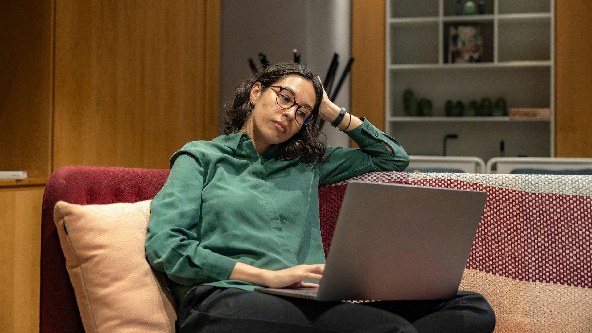 a woman sitting on a couch using a laptop computer