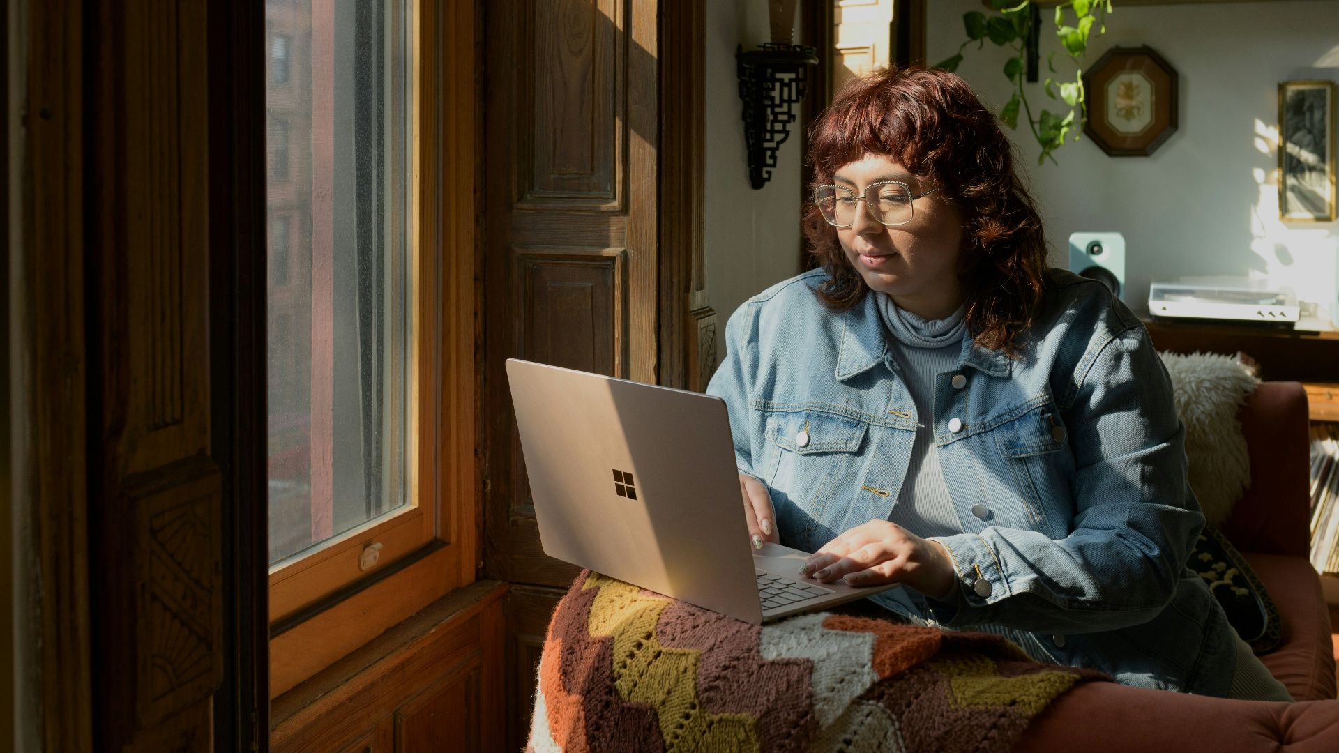 a woman sitting on a couch using a laptop computer