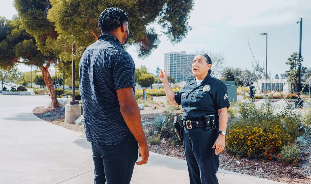 Police Officer Talking to Man in Black Shirt on the Street