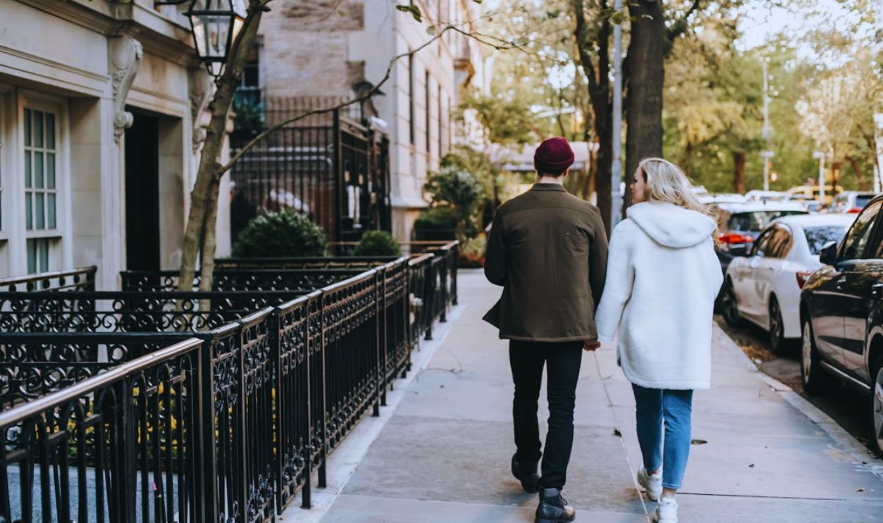 Stylish young couple walking in city residential district