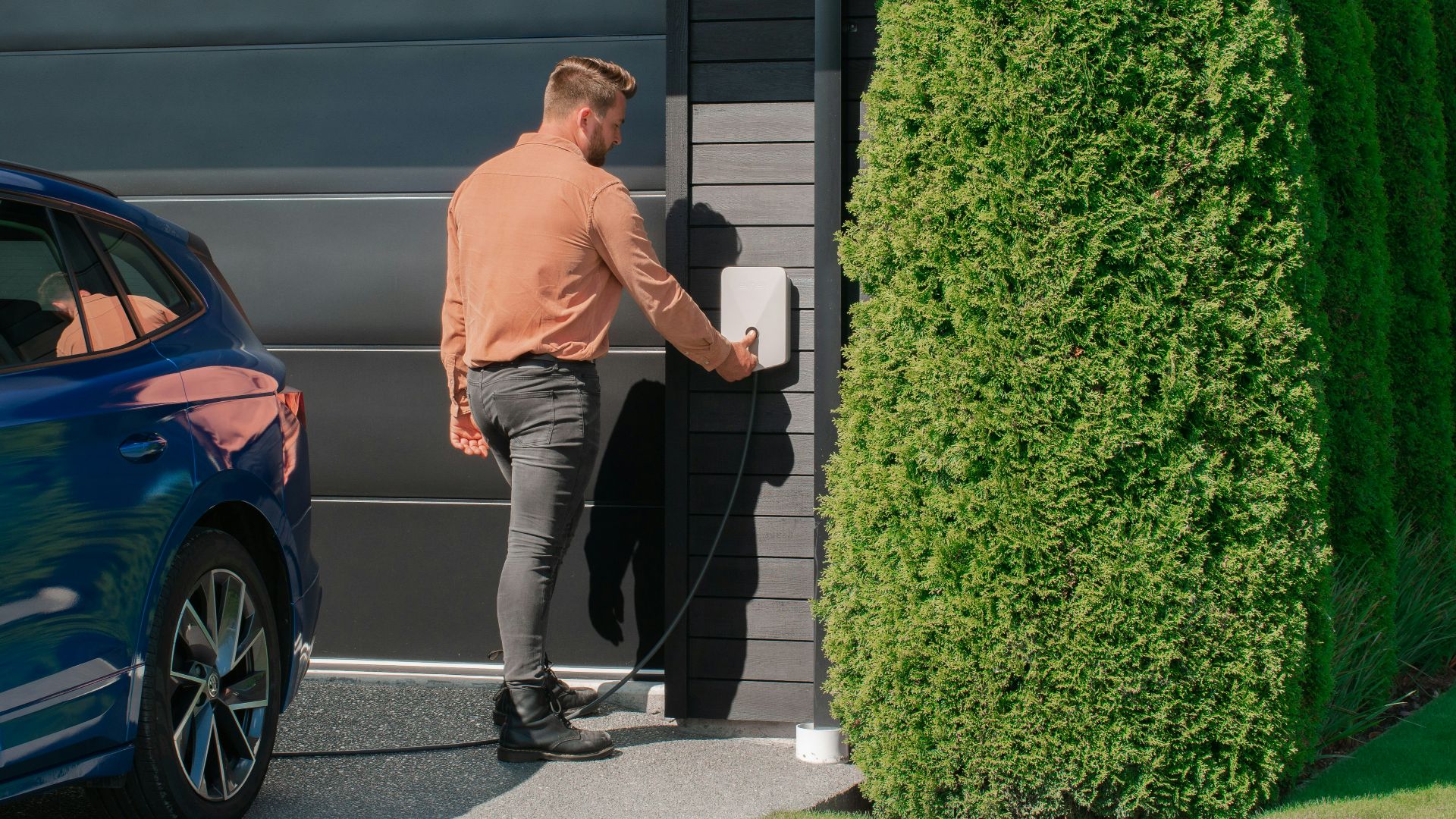 a man standing next to a blue car