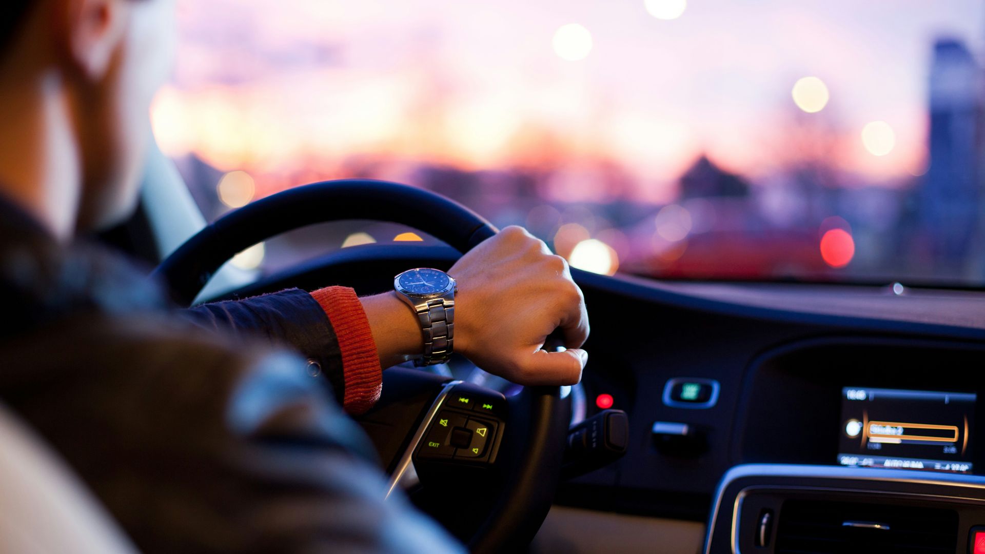man driving a car wearing wrist watch