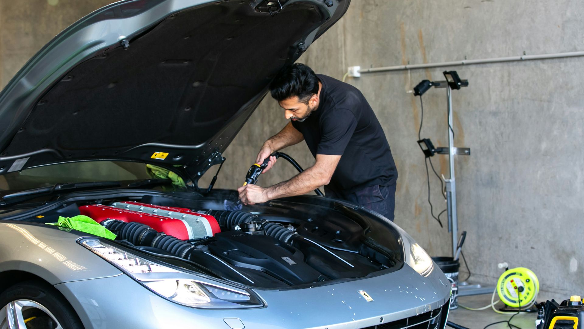A mechanic is working on a ferrari car.