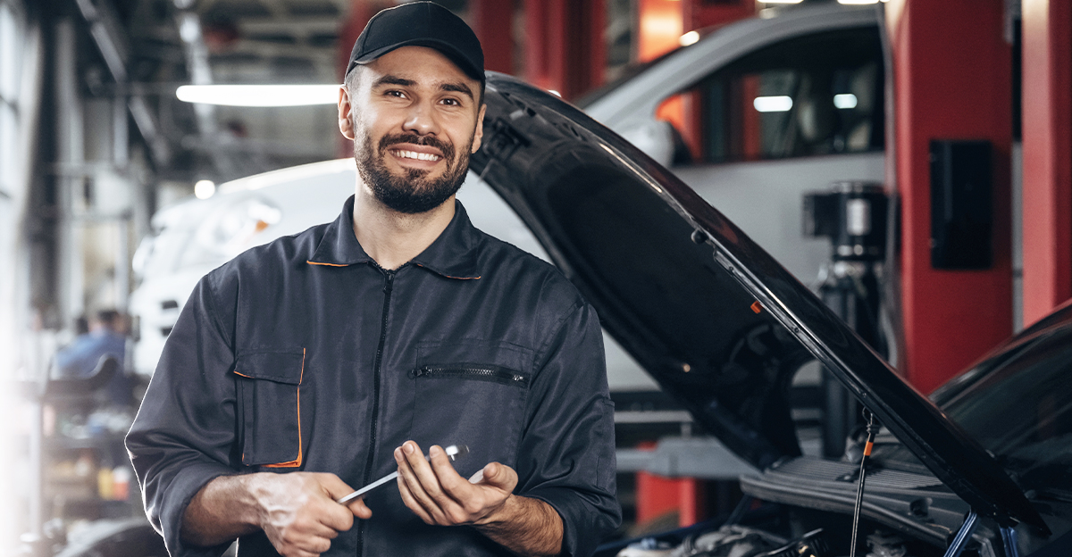 Mechanic standing in garage holding a tool