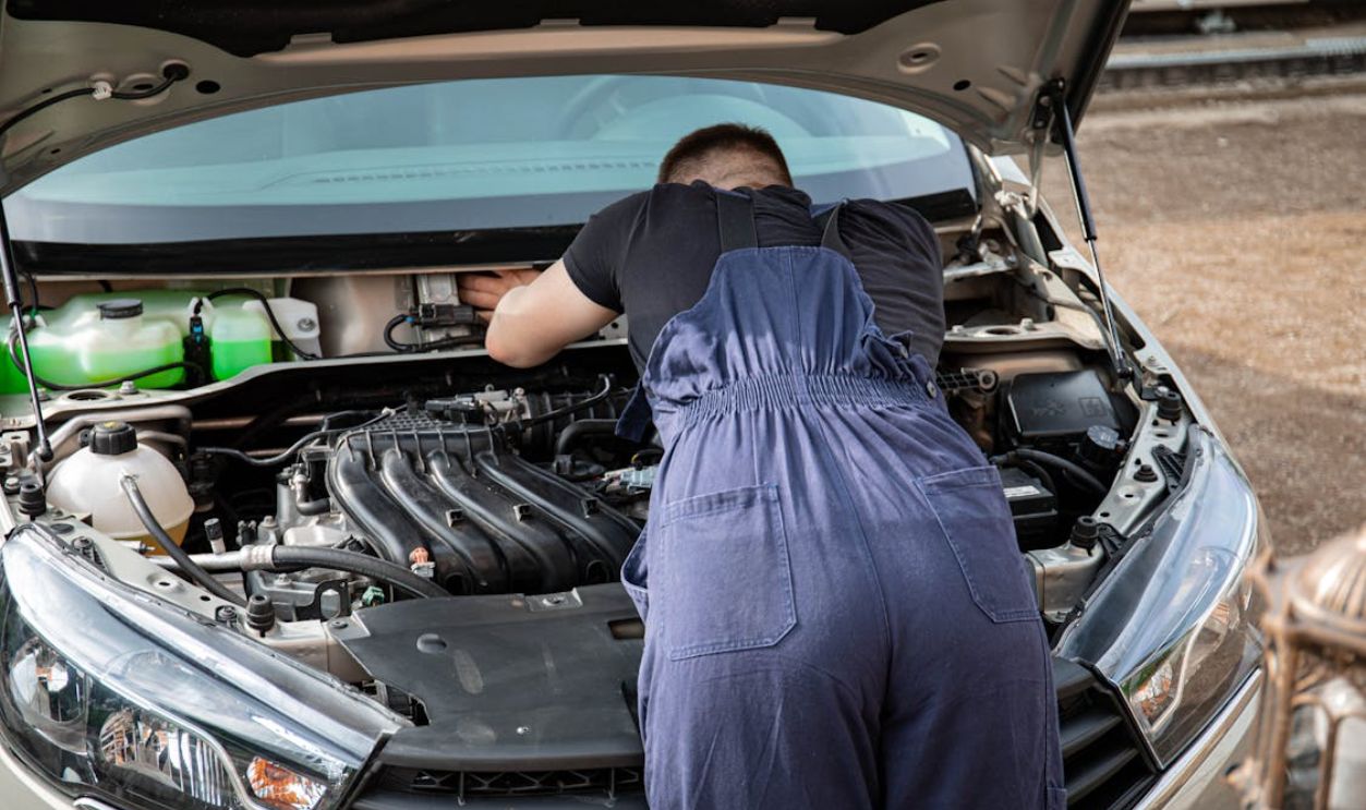 Man in Black Crew Neck T Shirt Fixing a Car