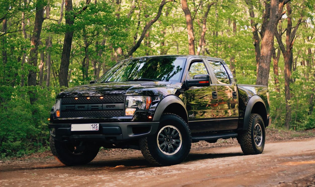 black and yellow chevrolet crew cab pickup truck parked on dirt road during daytime