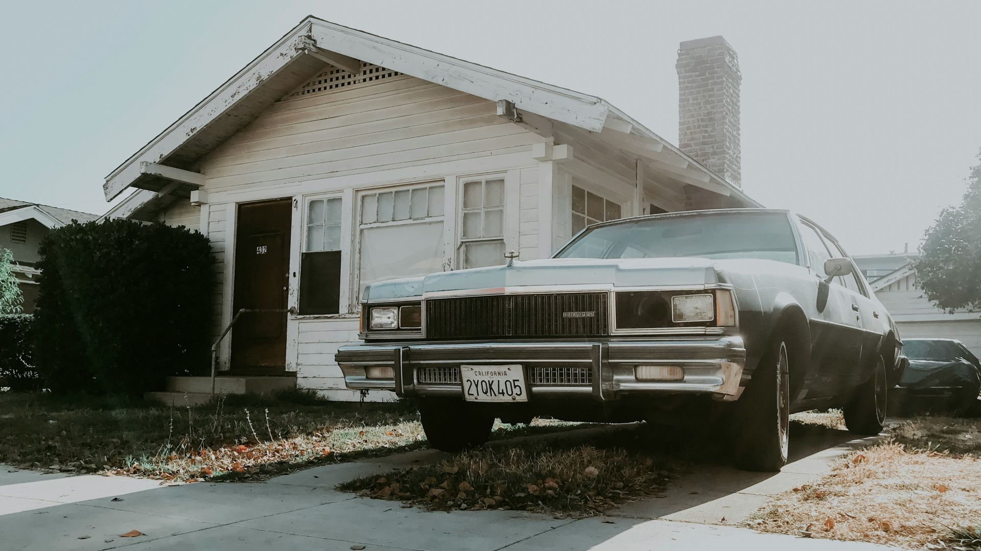 black sedan parked beside house
