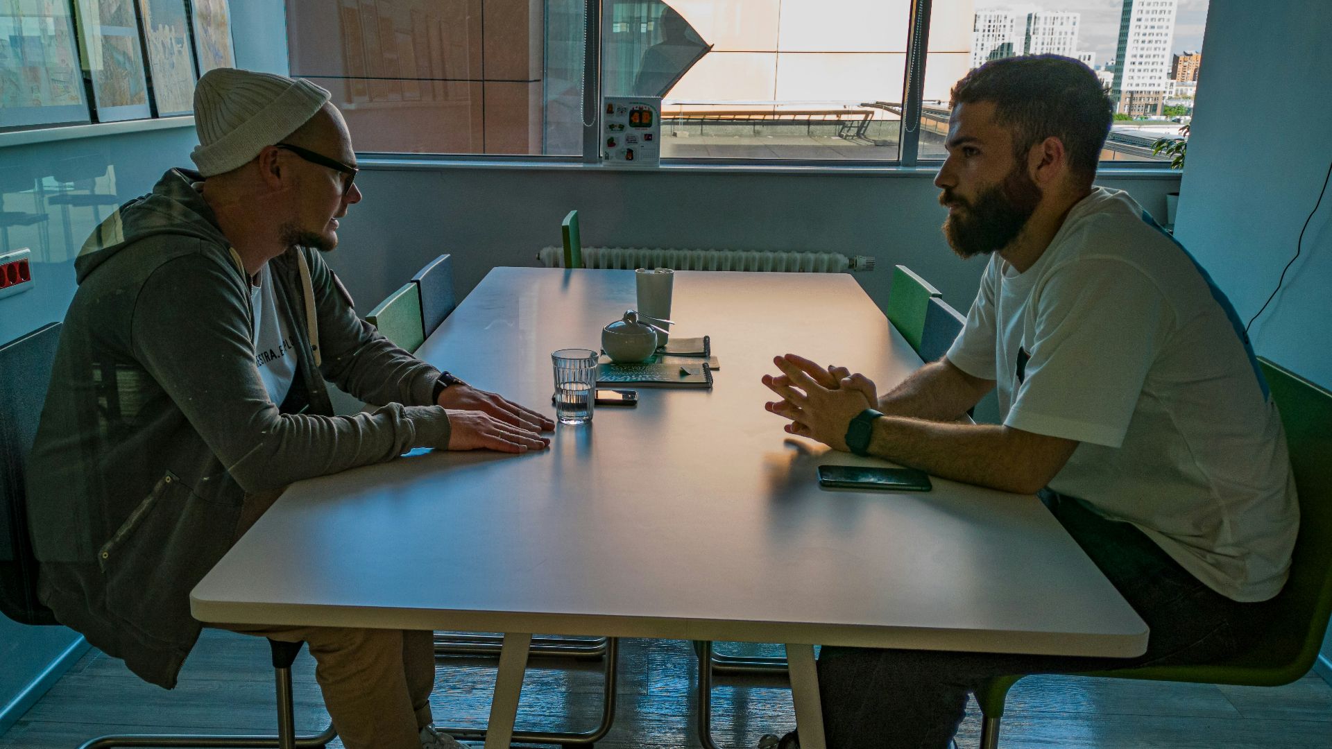 man in black jacket sitting beside man in gray jacket