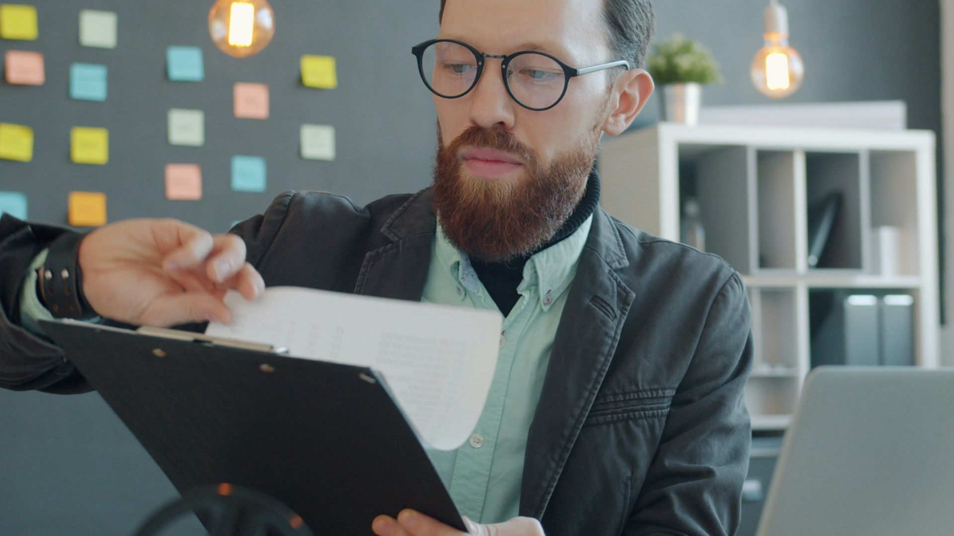 Man in glasses reviewing documents at desk
