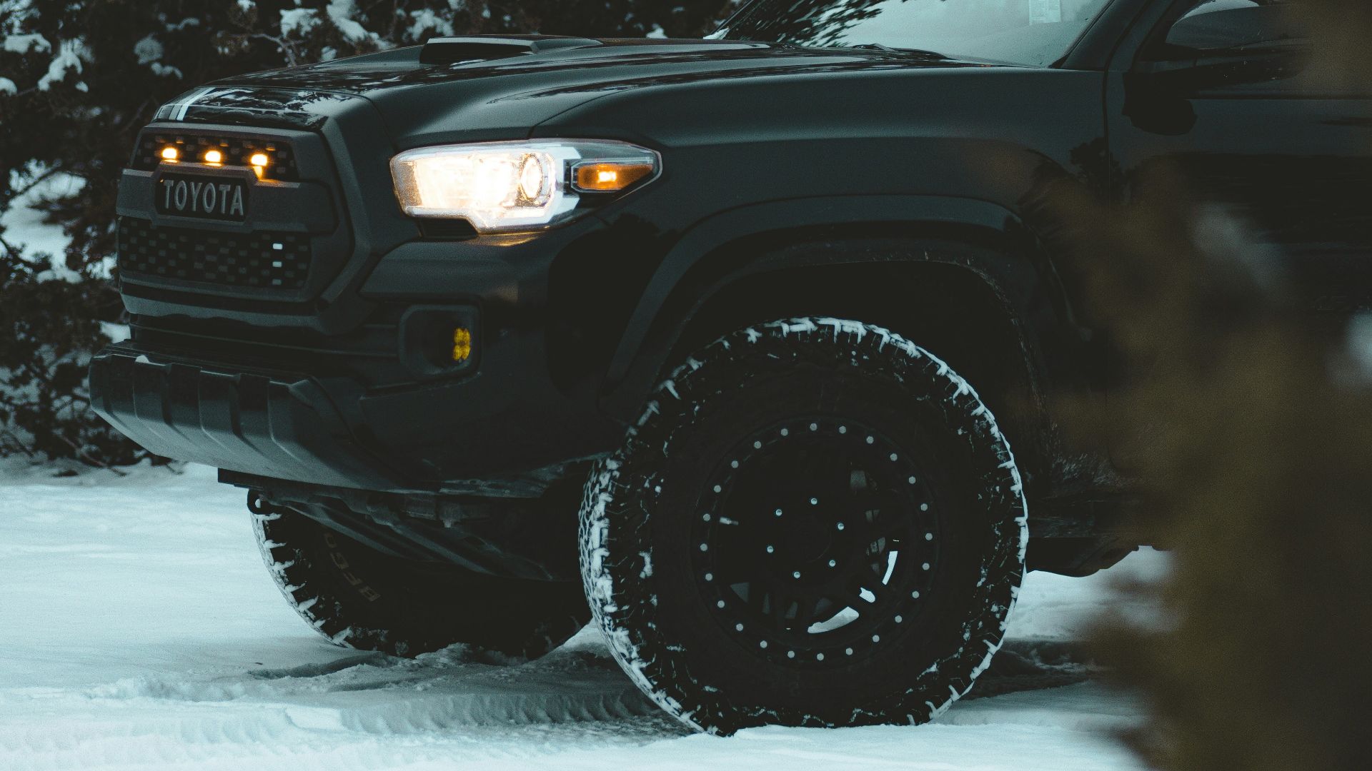 a black truck is parked in the snow