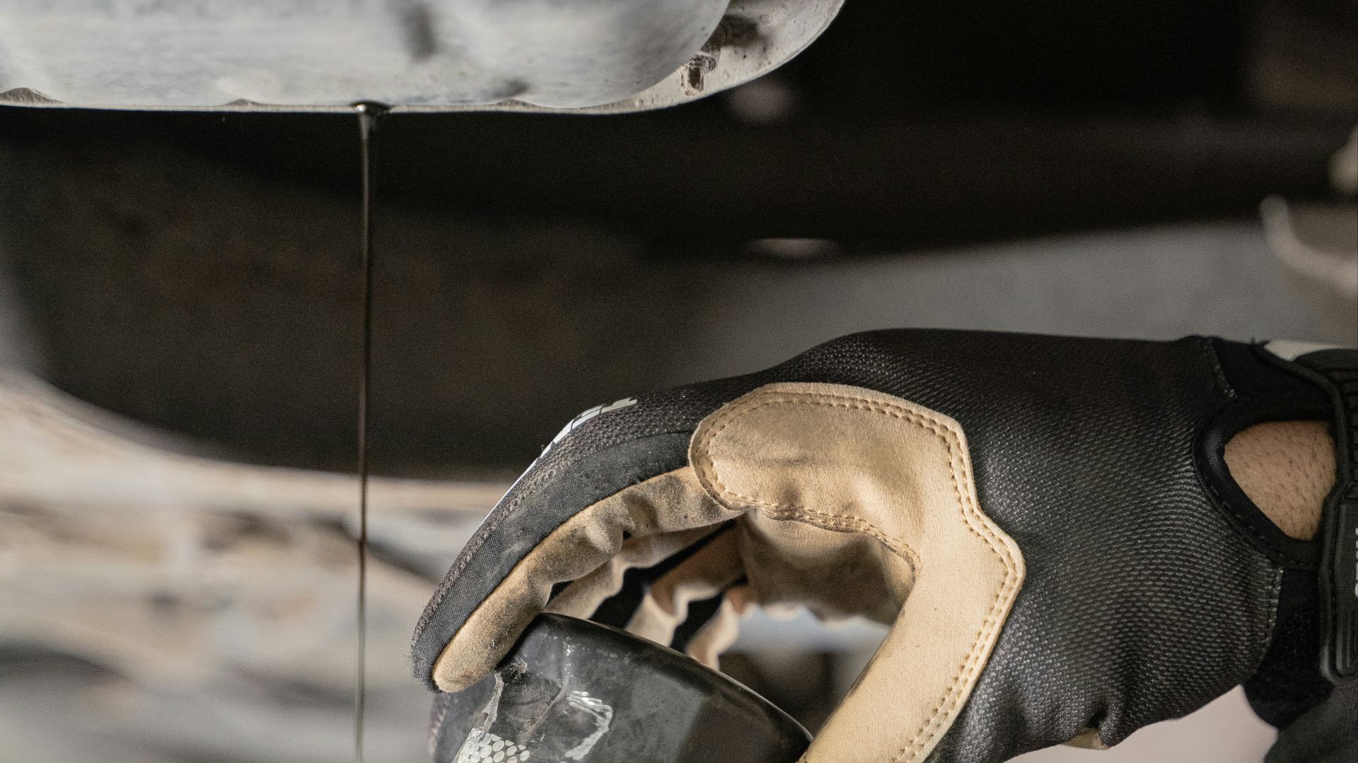 a mechanic is pouring oil on a car