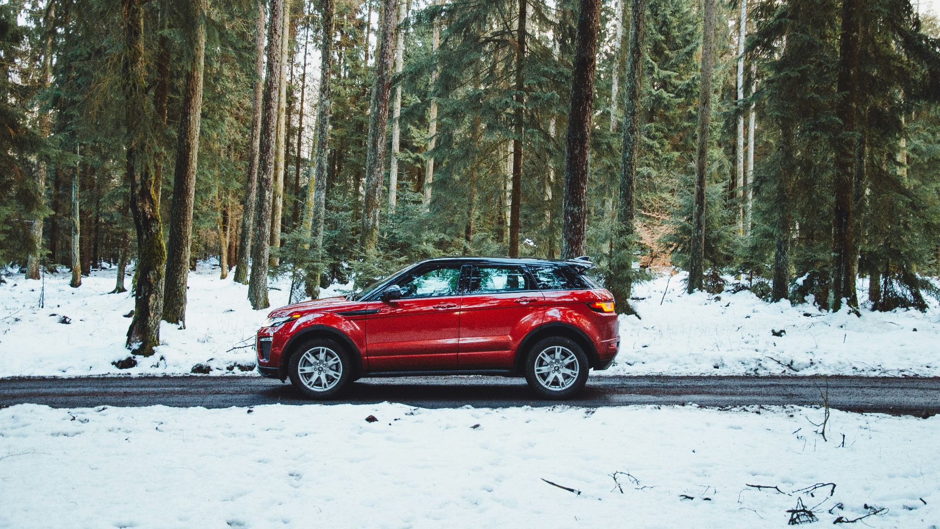 red suv on snow covered road during daytime