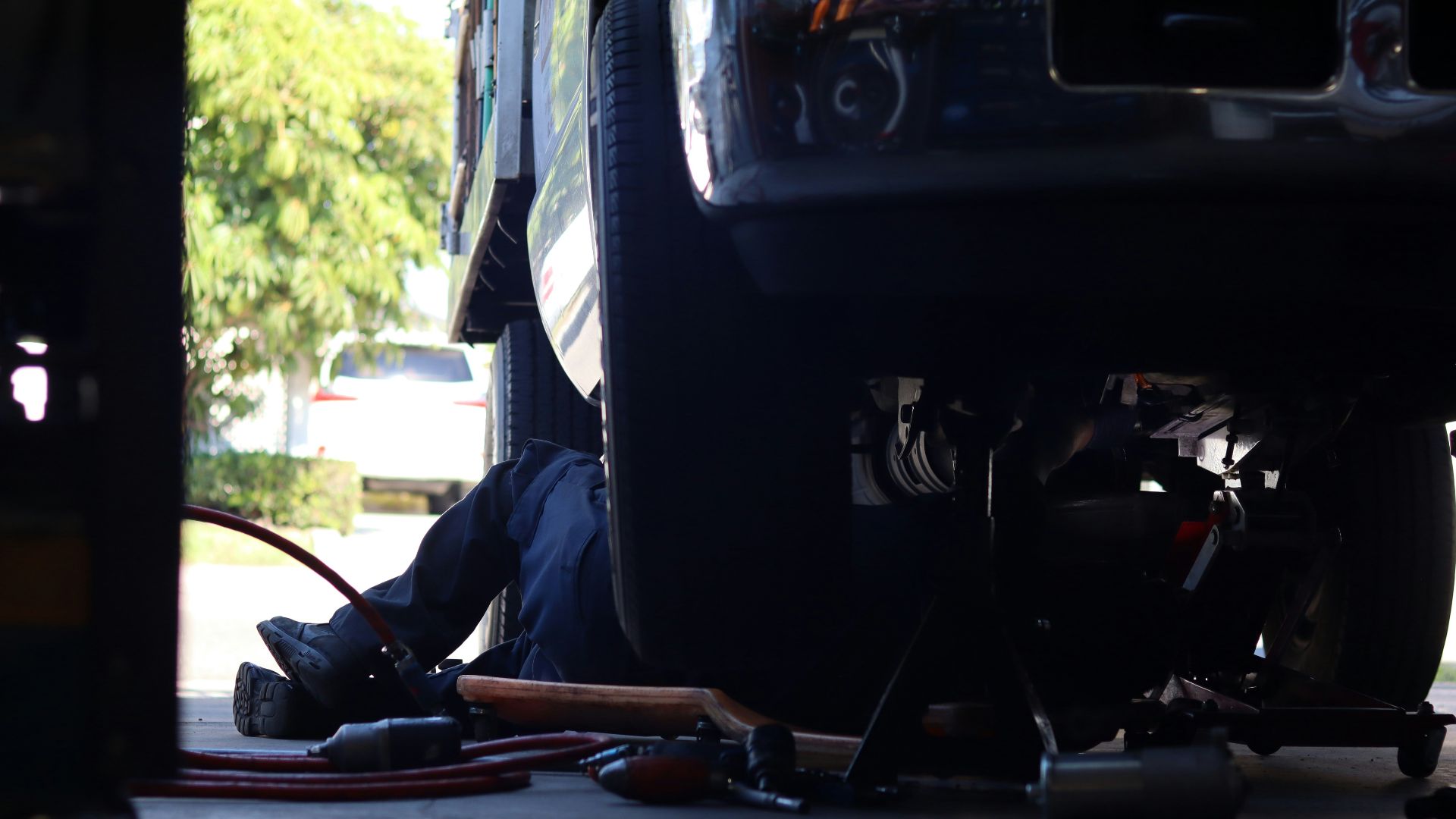a man working on a vehicle under a truck
