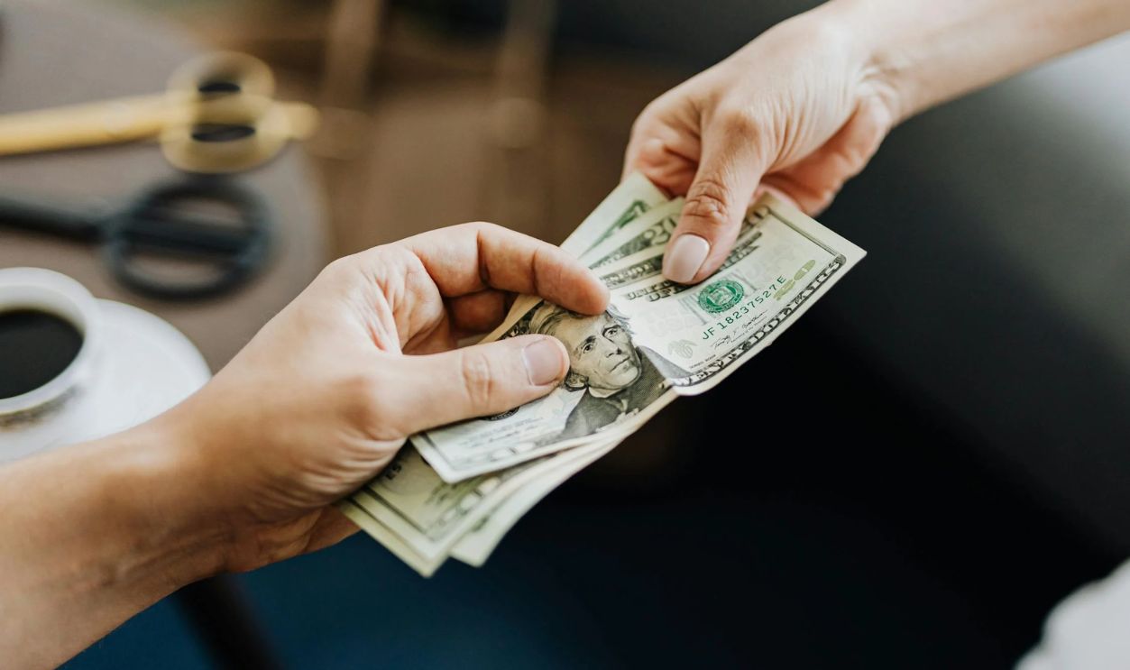 Hands Holding Us Dollar Bills