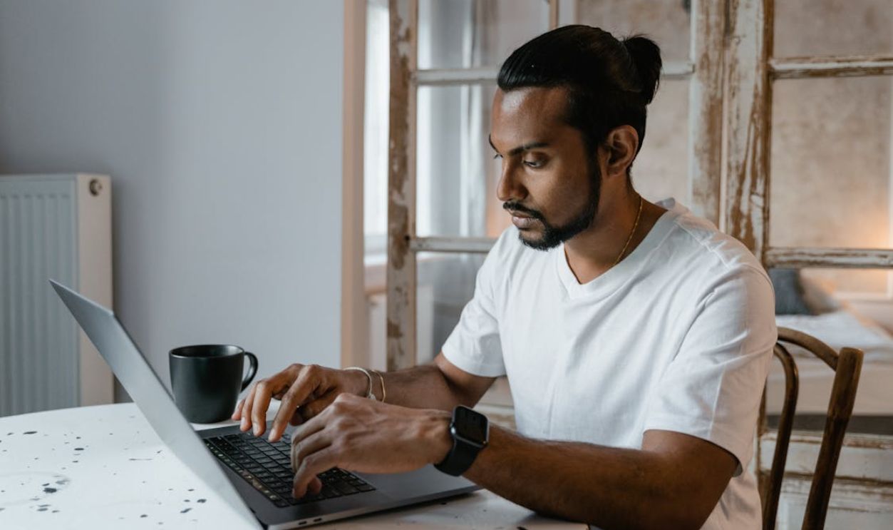 A Man Typing on a Laptop