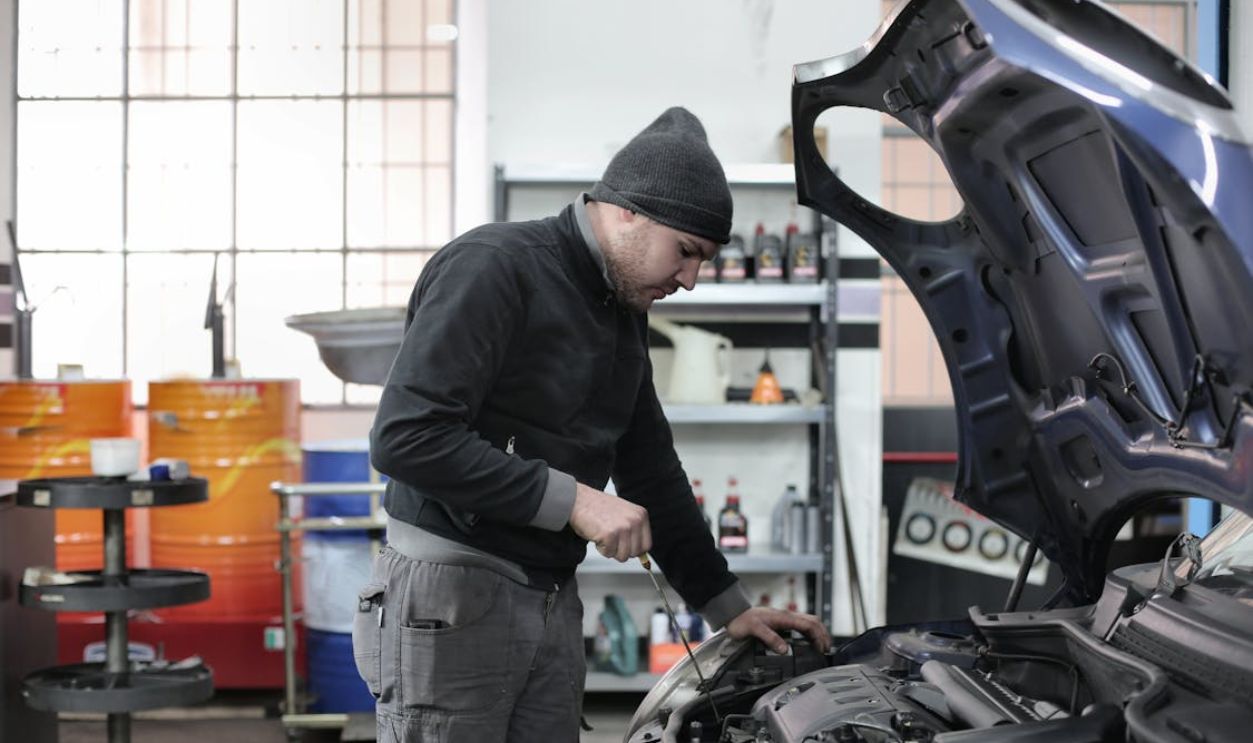 Photo of Man Inspecting Car Engine