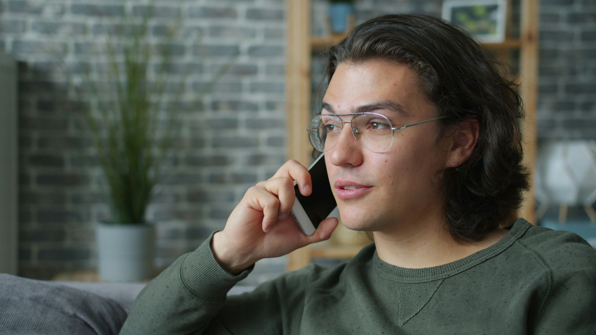 Man wearing glasses talking on a smartphone.