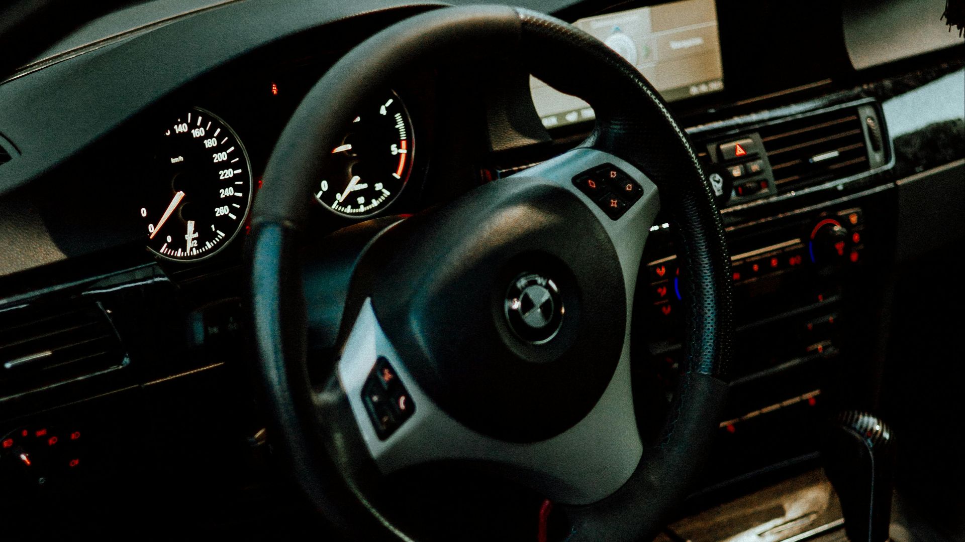 Detailed view of a car interior featuring a steering wheel, dashboard, and gear shift.
