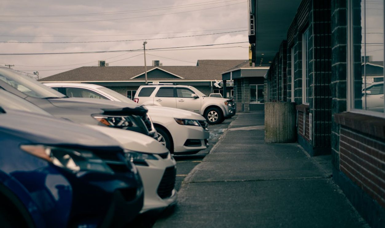 Modern cars parked on pavement against urban buildings