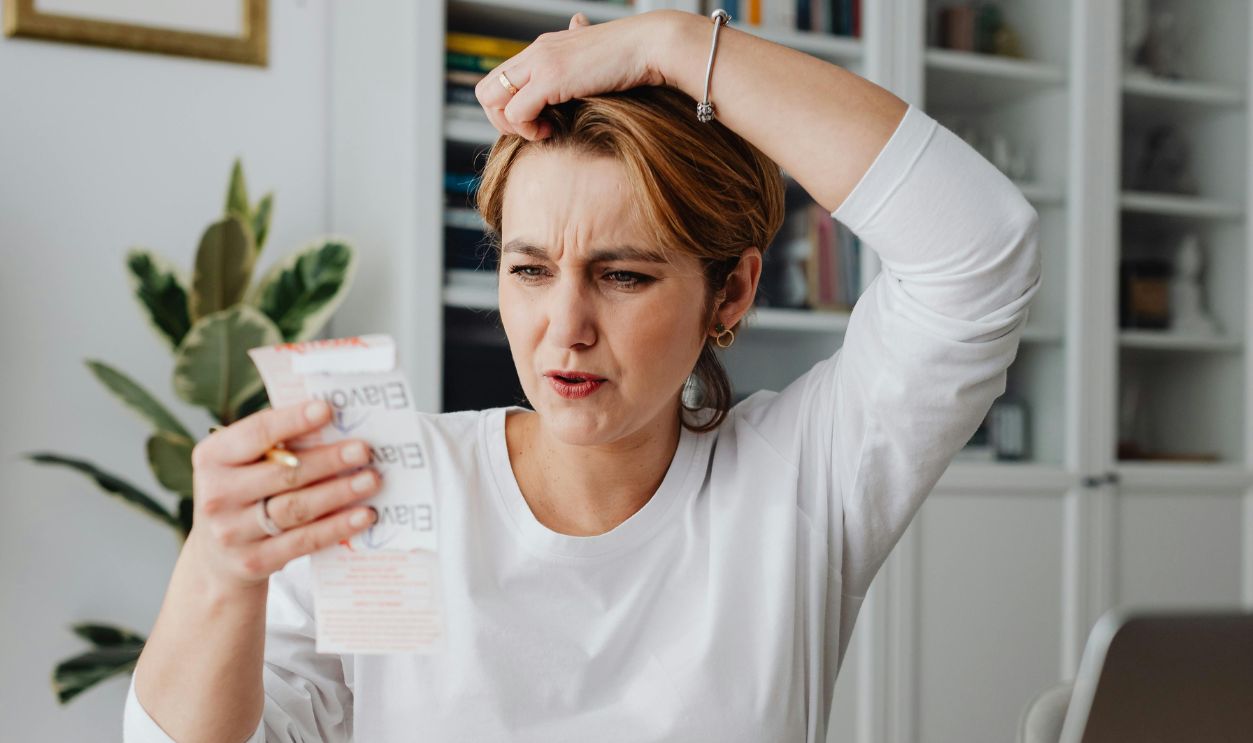 Woman Looking at a Receipt and Making a Surprised Face 